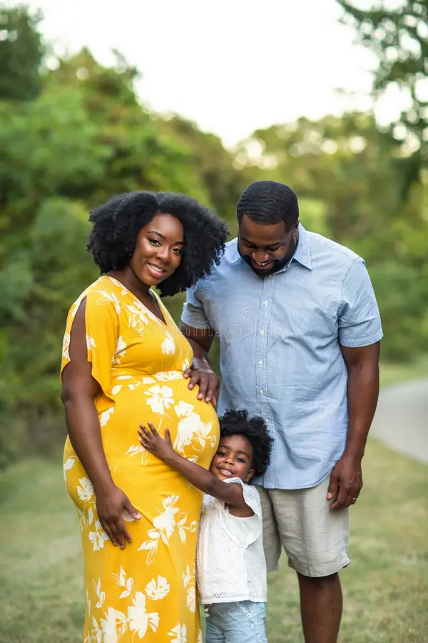 A pregnant Black woman walking with her family