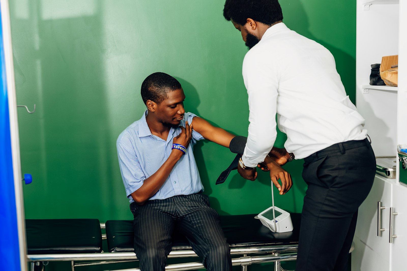 A clinician checking a man's blood pressure