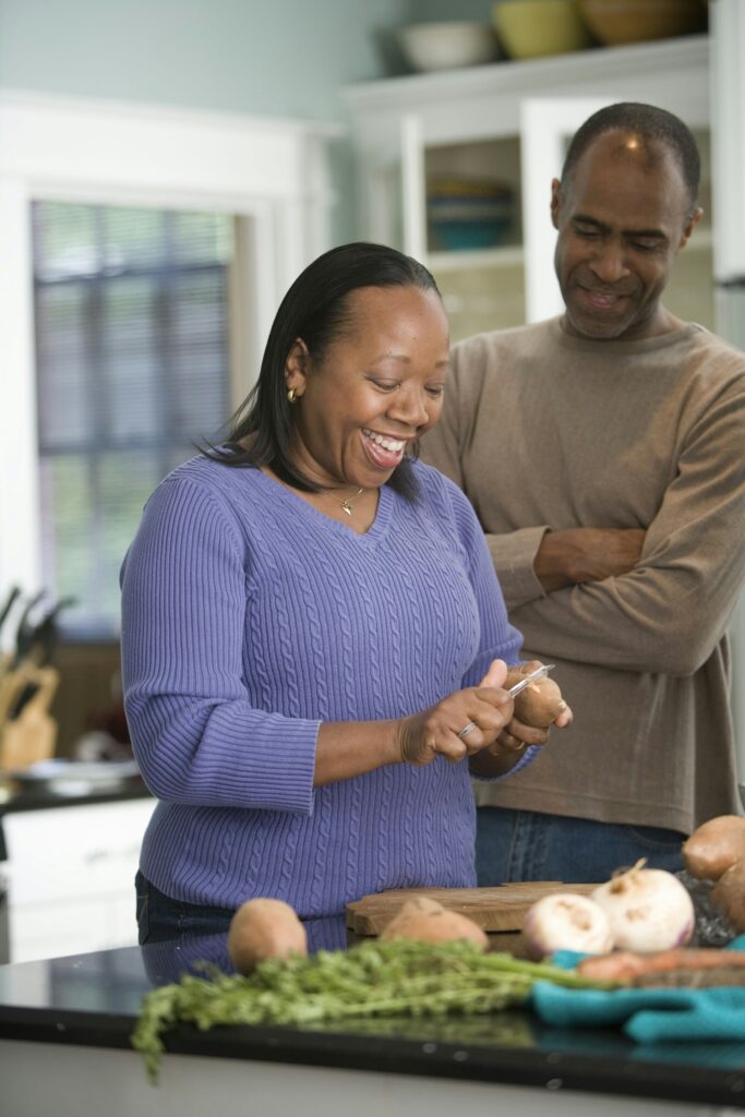 A Black couple preparing food together at home