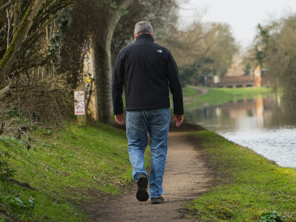 Illustrative lifestyle photograph of a man walking outdoors; photo by Caspar Rae on Unsplash